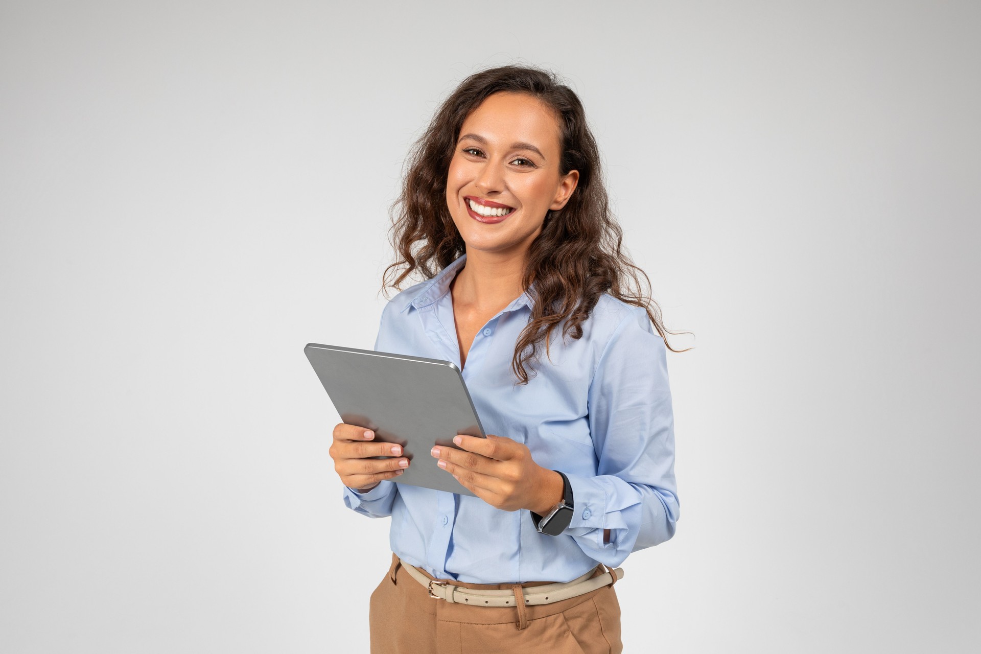 Smiling caucasian young businesswoman use tablet, app for social networks, presentation business