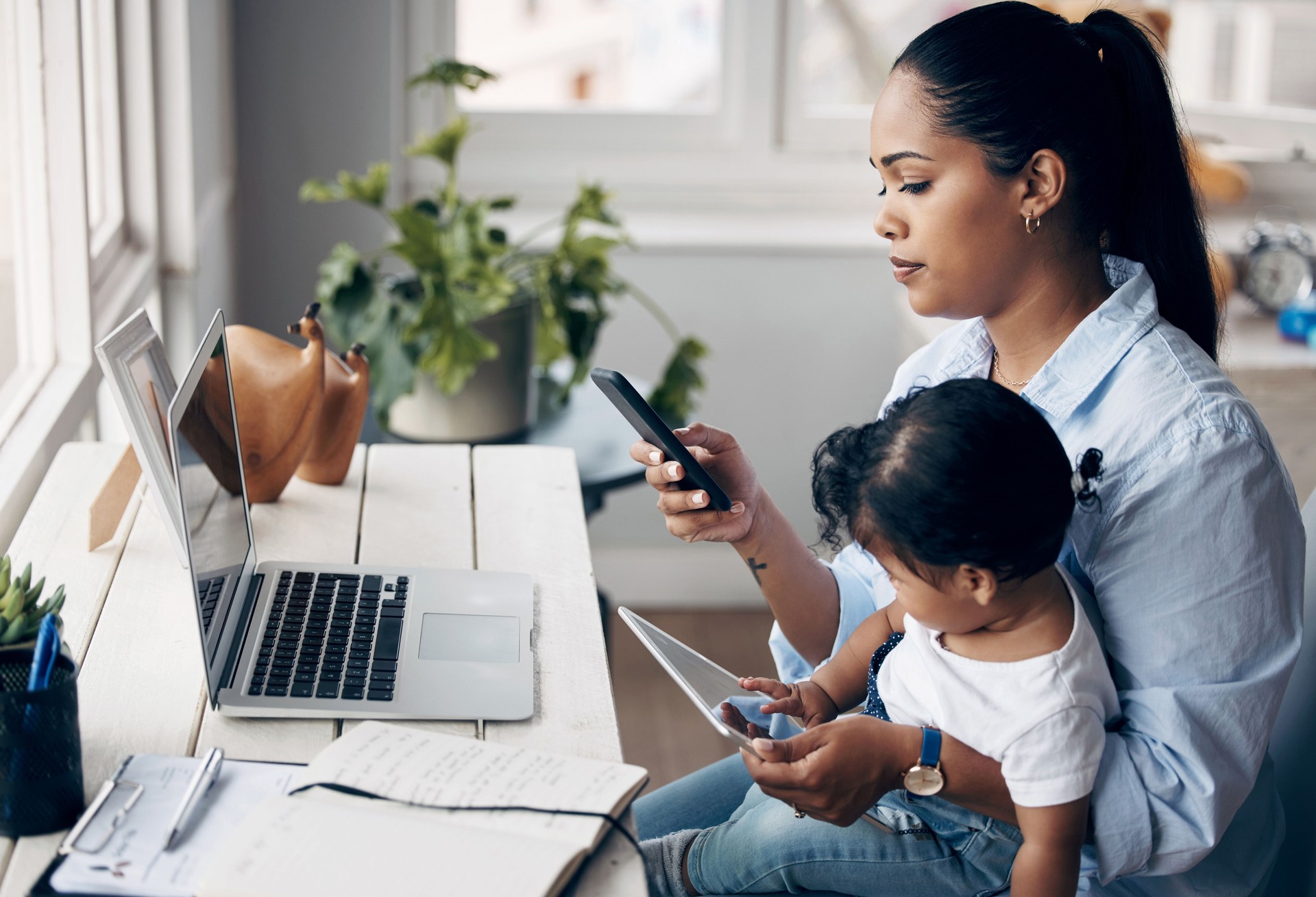 Shot of a young mother caring for her baby girl while working from home